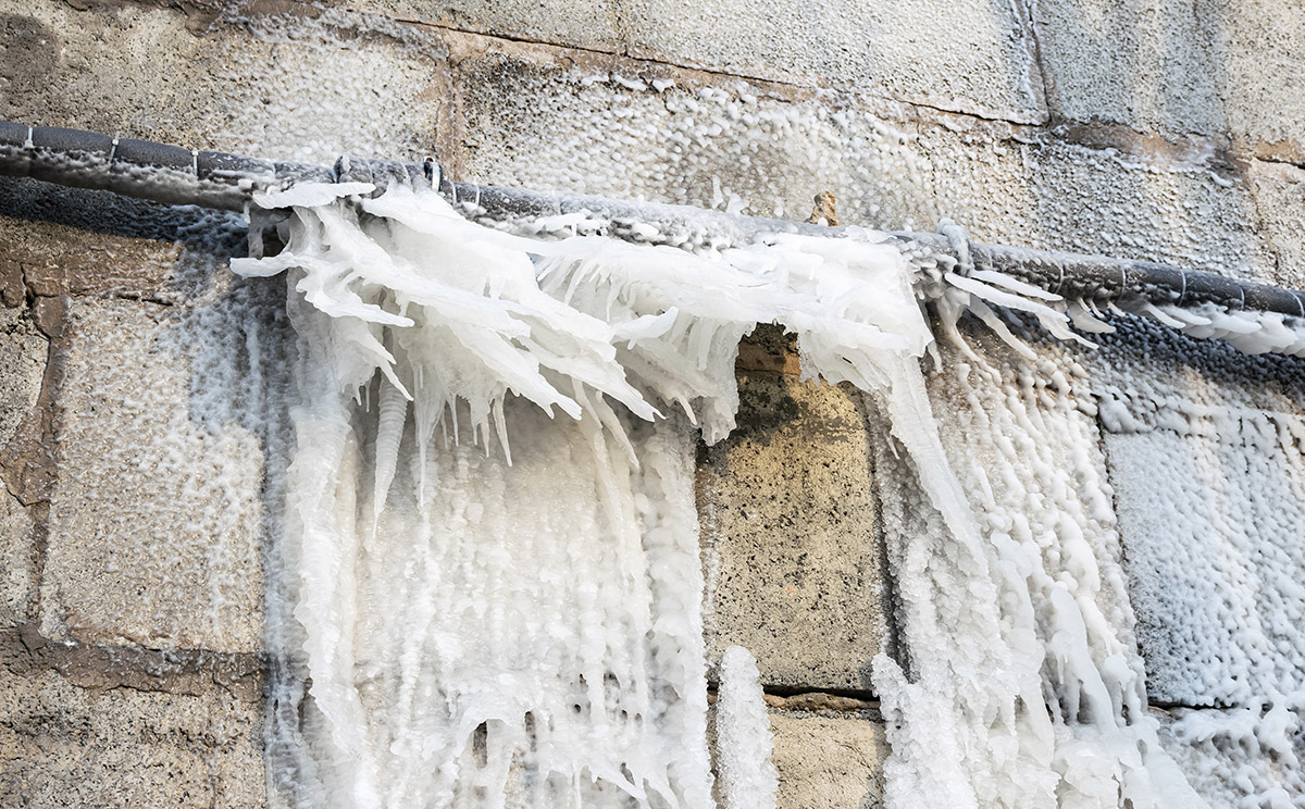 Frozen water after burst from a pipe at the winter.